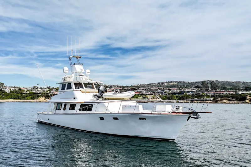 Amakua Yacht Photos Pics 1970 Hargrave Yachtfisher on calm water with scenic coastal background.