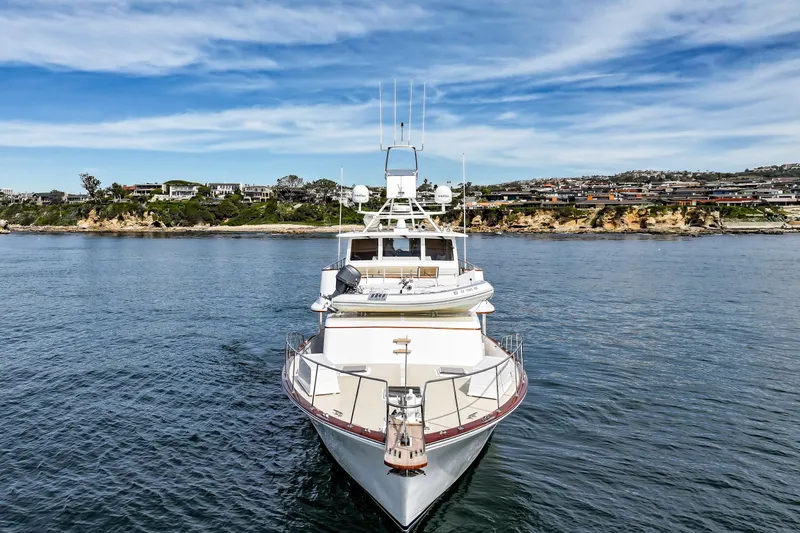 Amakua Yacht Photos Pics 1970 Hargrave Yachtfisher on calm waters with scenic coastal background.