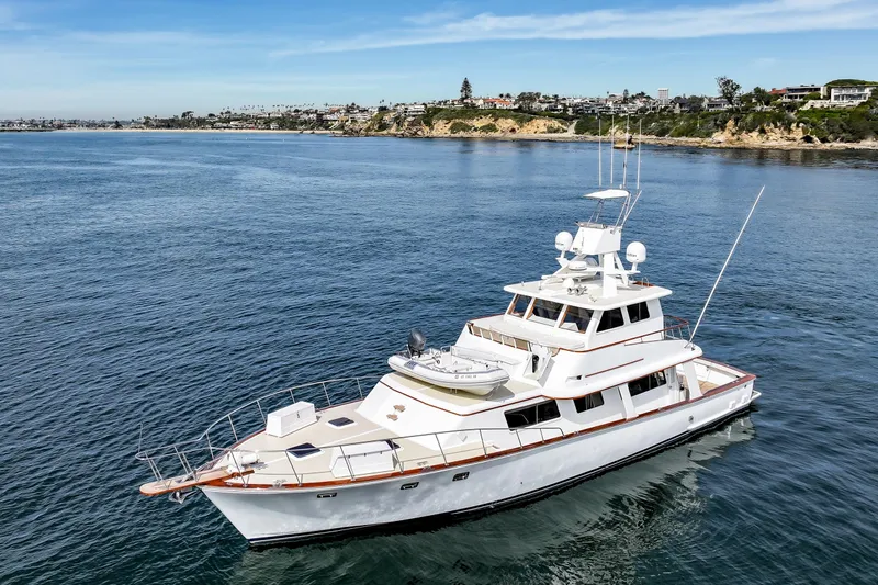 Amakua Yacht Photos Pics 1970 Hargrave Yachtfisher cruising near scenic coastline under clear blue sky.