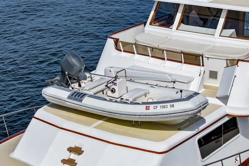Amakua Yacht Photos Pics 1970 Hargrave Yachtfisher with inflatable boat on deck, cruising on calm waters.