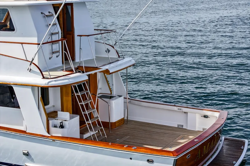 Amakua Yacht Photos Pics 1970 Hargrave Yachtfisher with wooden deck, docked on calm water.