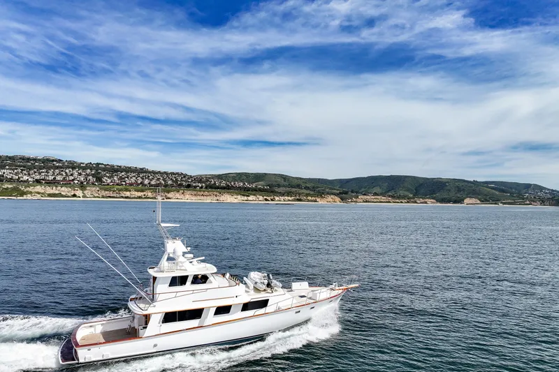 Amakua Yacht Photos Pics 1970 Hargrave Yachtfisher cruising on a scenic coastal waterway under a blue sky.