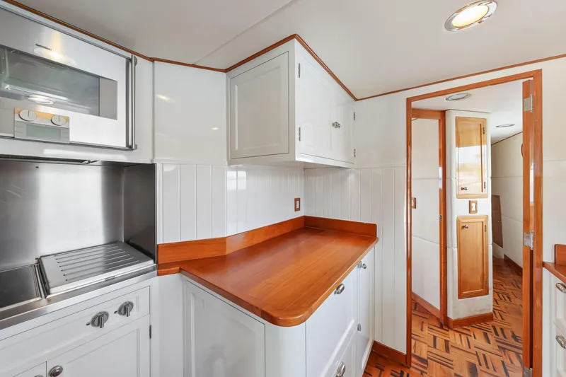 Amakua Yacht Photos Pics 1970 Hargrave Yachtfisher kitchen with wood countertops and white cabinetry.