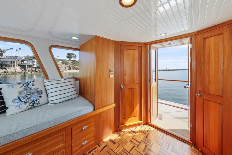 Amakua Yacht Photos Pics Interior of 1970 Hargrave Yachtfisher with wooden finish, cozy seating, and ocean view.