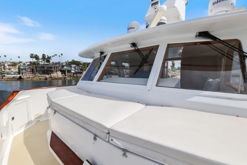 Amakua Yacht Photos Pics 1970 Hargrave Yachtfisher with spacious deck, docked near waterfront homes.