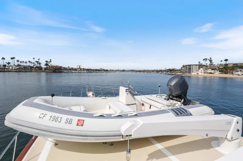 Amakua Yacht Photos Pics 1970 Hargrave Yachtfisher with inflatable boat on deck, overlooking serene coastal waters.