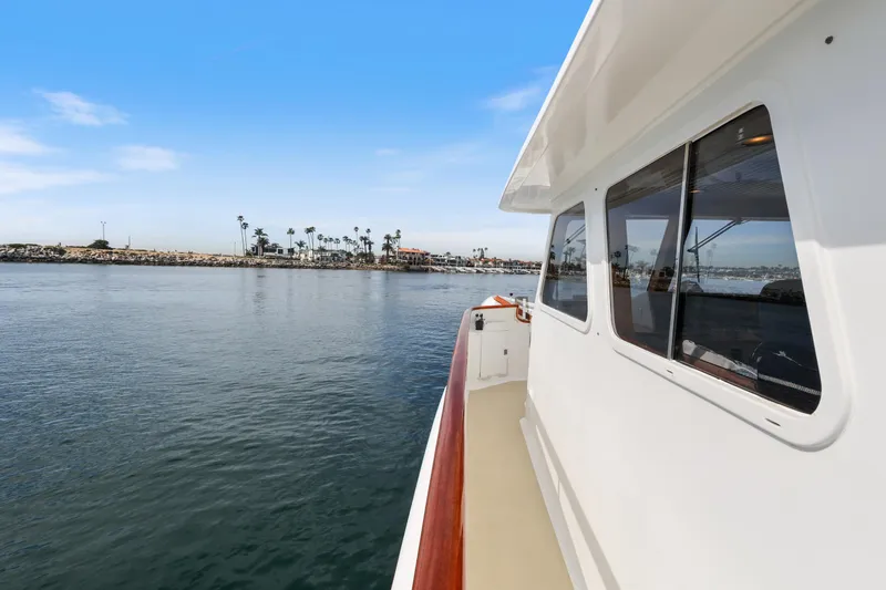 Amakua Yacht Photos Pics 1970 Hargrave Yachtfisher cruising near a coastal harbor with palm trees.