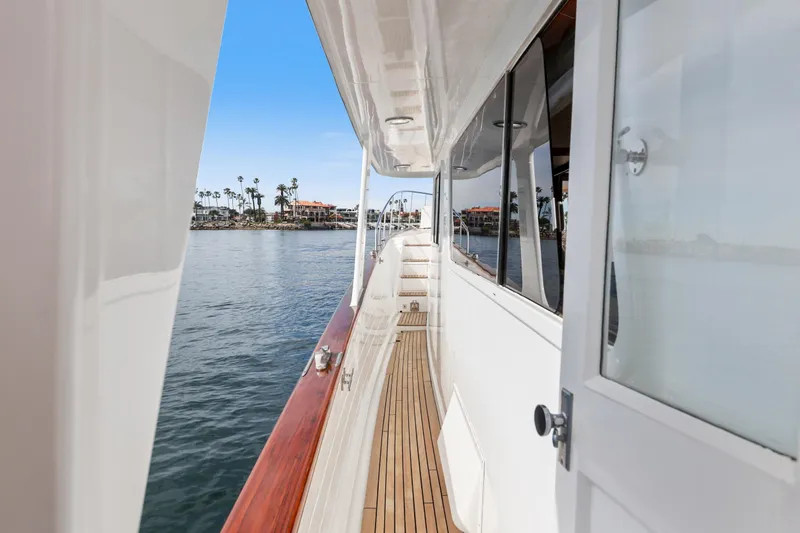 Amakua Yacht Photos Pics Side deck view of 1970 Hargrave Yachtfisher, showcasing teak flooring and ocean backdrop.