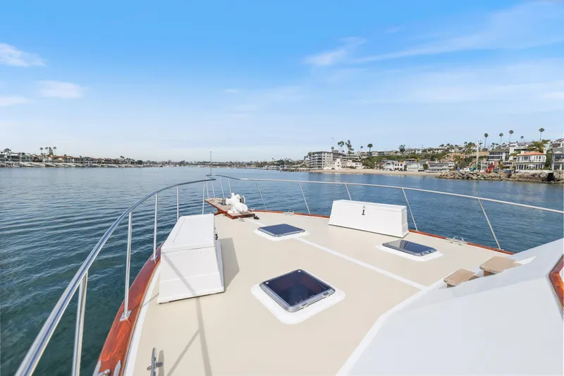 Amakua Yacht Photos Pics 1970 Hargrave Yachtfisher cruising on calm waters near coastal homes under a clear blue sky.