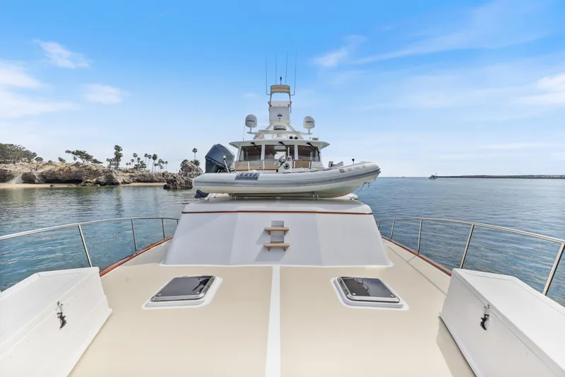 Amakua Yacht Photos Pics 1970 Hargrave Yachtfisher on calm waters, featuring a spacious deck and tender boat.