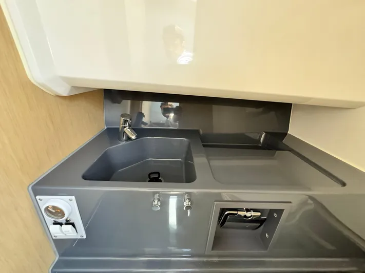  Yacht Photos Pics Compact kitchen area in the 2024 Windy SR28 CC boat with sink and faucet.