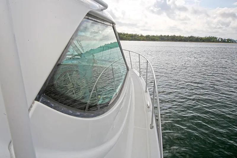 Ciao Bella Yacht Photos Pics 2007 Tiara Yachts 3900 Sovran cruising on calm waters near a forested shoreline.