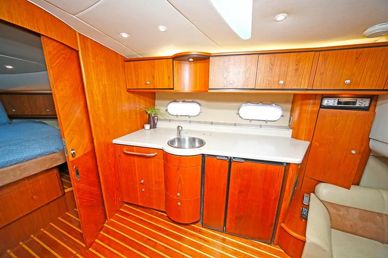 Ciao Bella Yacht Photos Pics 2007 Tiara Yachts 3900 Sovran interior with wooden cabinetry and compact kitchenette.