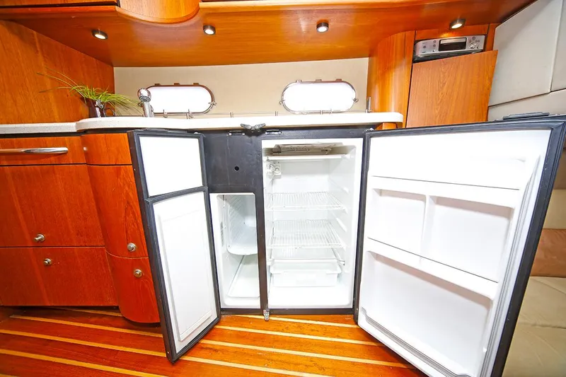 Ciao Bella Yacht Photos Pics 2007 Tiara Yachts 3900 Sovran interior with open refrigerator, wooden cabinetry, and flooring.