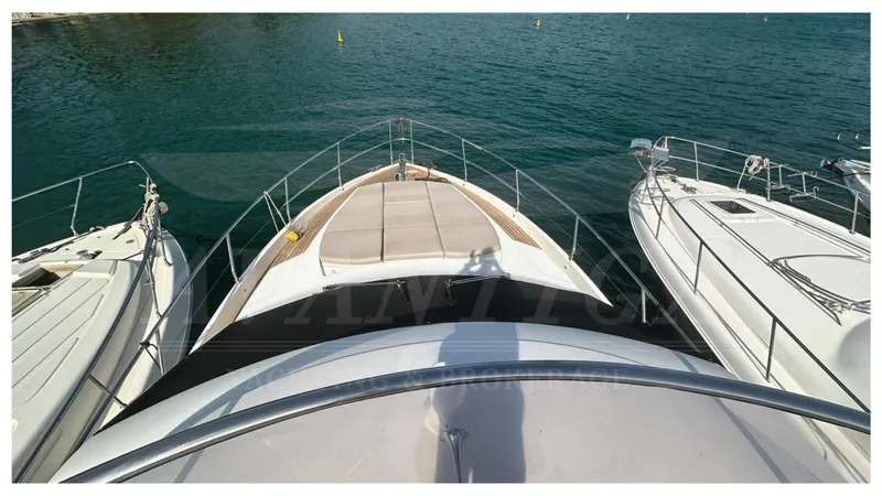  Yacht Photos Pics Absolute 52 FLY yacht, 2014 model, docked between two boats on calm water.