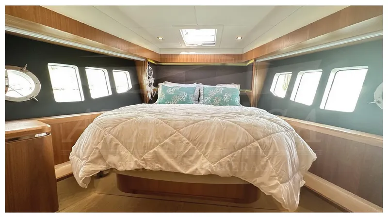  Yacht Photos Pics Luxurious bedroom interior of 2014 Absolute 52 FLY yacht with large windows and cozy bedding.