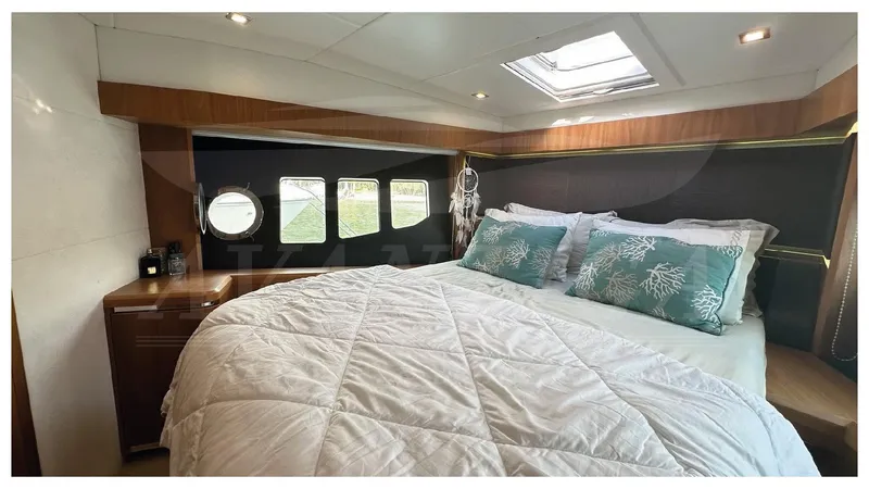  Yacht Photos Pics Luxurious bedroom interior of 2014 Absolute 52 FLY yacht with skylight and porthole windows.