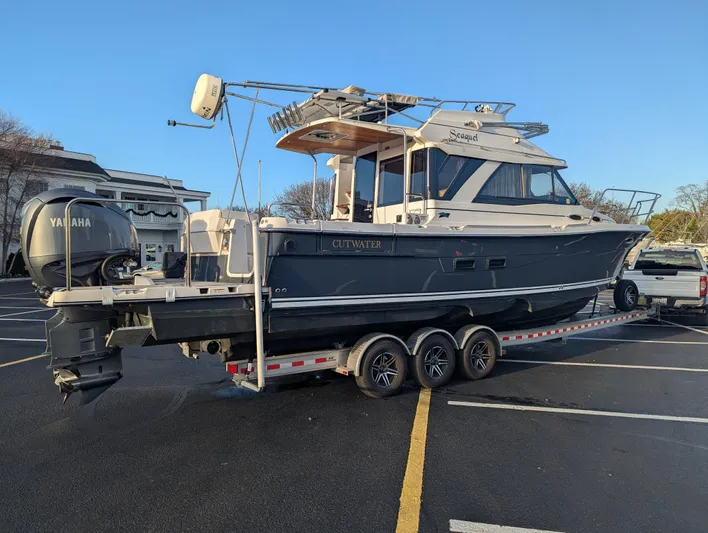  Yacht Photos Pics 2022 Cutwater C-32 CB boat on trailer in parking lot, side view.