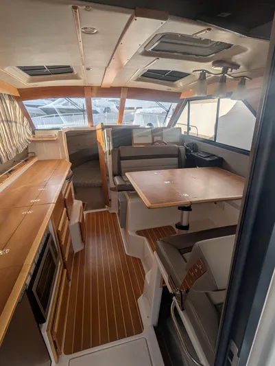  Yacht Photos Pics Interior of 2022 Cutwater C-32 CB boat with modern wood finish and seating area.