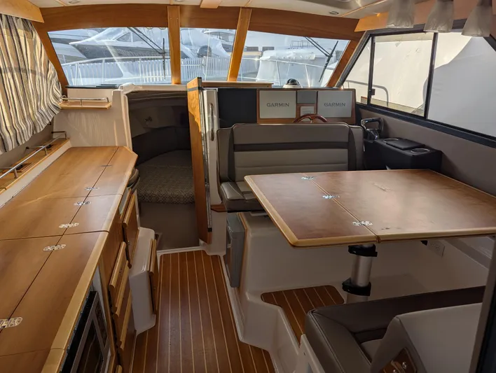  Yacht Photos Pics Interior of 2022 Cutwater C-32 CB boat with wood finishes and seating area.