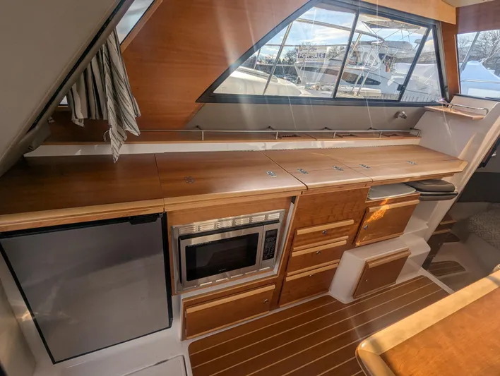  Yacht Photos Pics 2022 Cutwater C-32 CB yacht interior with modern kitchen and wood finish.