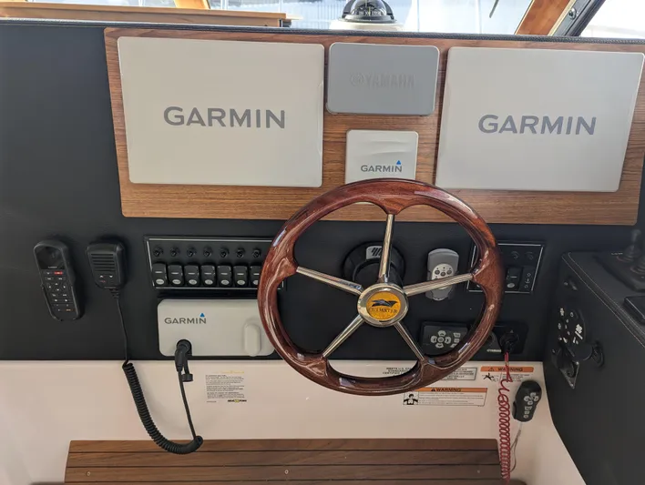  Yacht Photos Pics 2022 Cutwater C-32 CB helm with Garmin navigation and wooden steering wheel.