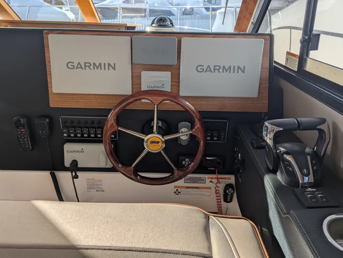  Yacht Photos Pics 2022 Cutwater C-32 CB helm with Garmin navigation system and wooden steering wheel.