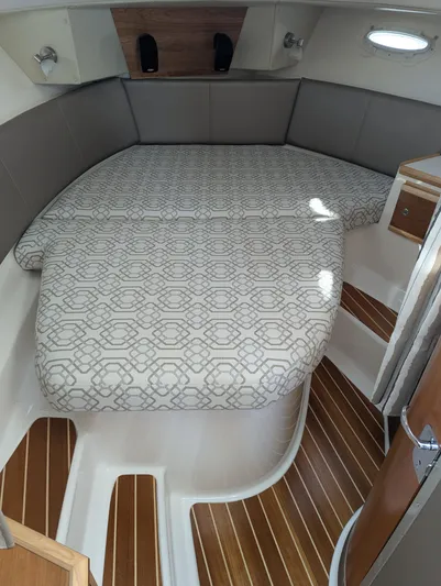  Yacht Photos Pics 2022 Cutwater C-32 CB cabin interior with patterned bedding and wood accents.
