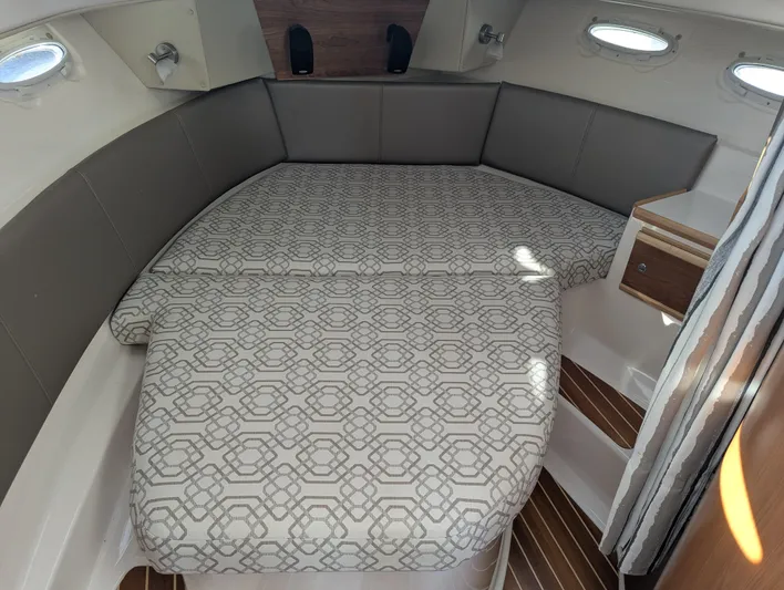  Yacht Photos Pics 2022 Cutwater C-32 CB cabin interior with patterned bed and wood accents.