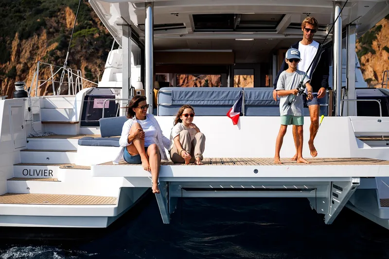 Voila Yacht Photos Pics Family enjoying leisure time on a 2026 Bali 5.2 yacht, with scenic coastal backdrop.