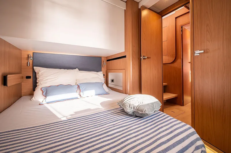 Voila Yacht Photos Pics Luxurious cabin interior of 2026 Bali 5.2 yacht with cozy bedding and wooden finishes.