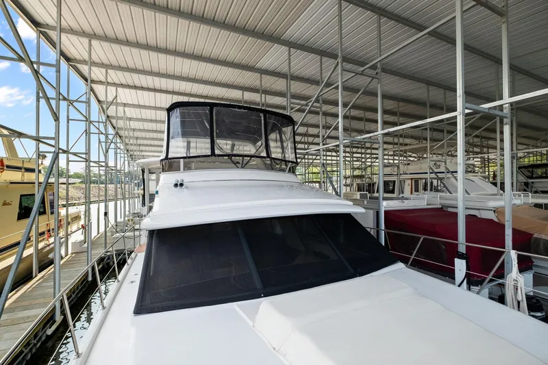 Starship Yacht Photos Pics 1996 Carver 440 Aft Cabin Motor Yacht docked under metal canopy.