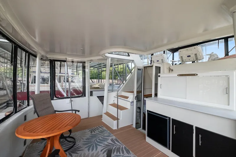 Starship Yacht Photos Pics 1996 Carver 440 Aft Cabin Motor Yacht interior with seating, table, and storage cabinets.