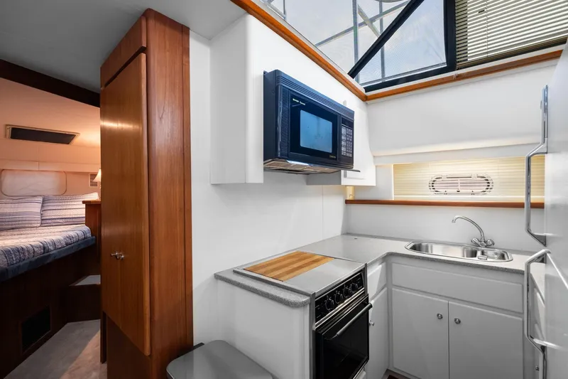 Starship Yacht Photos Pics 1996 Carver 440 Aft Cabin Motor Yacht kitchen with microwave, stove, and sink.
