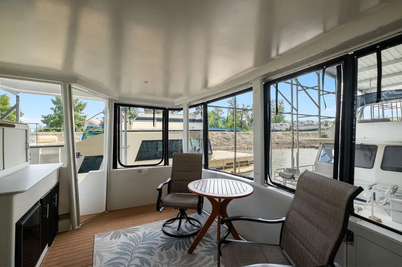 Starship Yacht Photos Pics 1996 Carver 440 Aft Cabin Motor Yacht interior with seating and table, docked by the water.