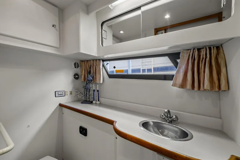Starship Yacht Photos Pics Interior of 1996 Carver 440 Aft Cabin Motor Yacht bathroom with sink and window.