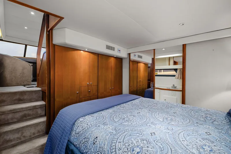 Starship Yacht Photos Pics Luxurious 1996 Carver 440 Aft Cabin Motor Yacht bedroom with elegant wood cabinetry.