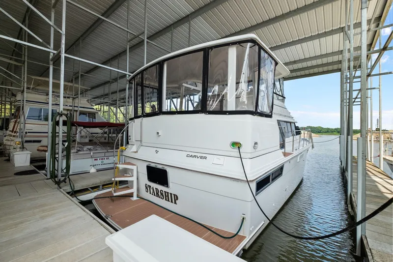 Starship Yacht Photos Pics 1996 Carver 440 Aft Cabin Motor Yacht docked in a covered marina.