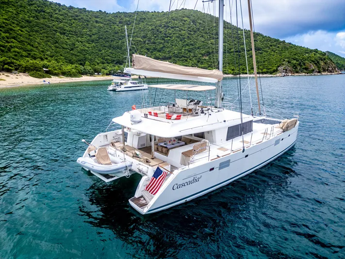 Cascadia 2 Yacht Photos Pics Lagoon 560 catamaran, 2012 model, anchored in scenic bay with lush green hills.