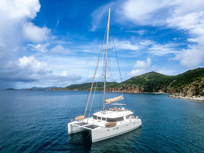 Cascadia 2 Yacht Photos Pics Lagoon 560 catamaran sailing in serene blue waters near lush green islands, 2012 model.