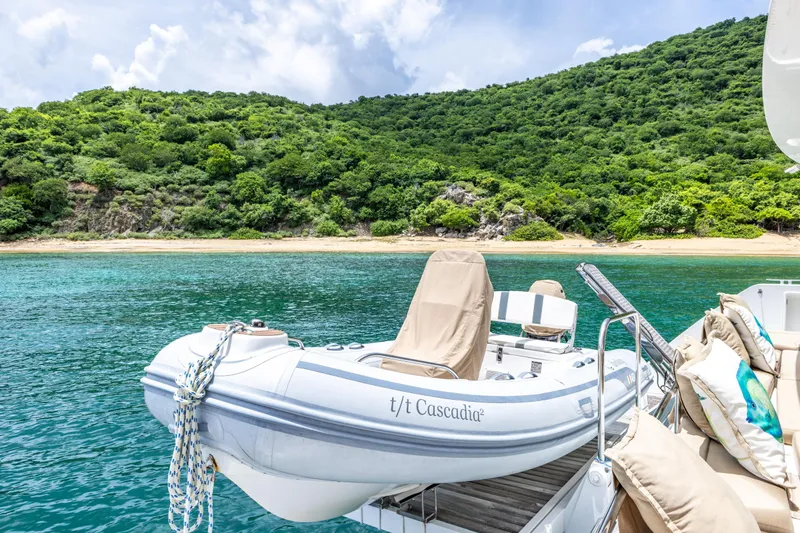 Cascadia 2 Yacht Photos Pics Lagoon 560 yacht with dinghy, anchored near lush green island, 2012 model.