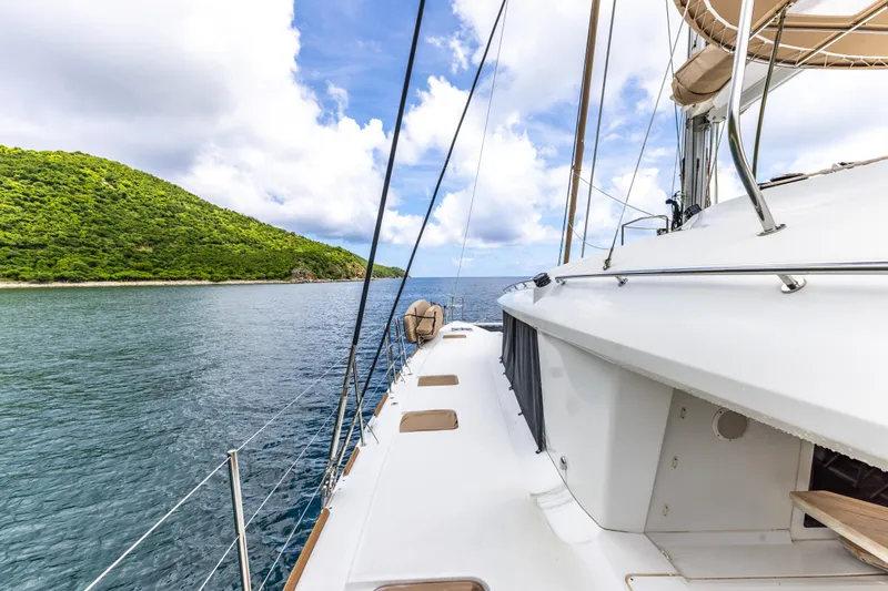 Cascadia 2 Yacht Photos Pics Lagoon 560 yacht sailing near lush green island under blue sky, 2012 model.