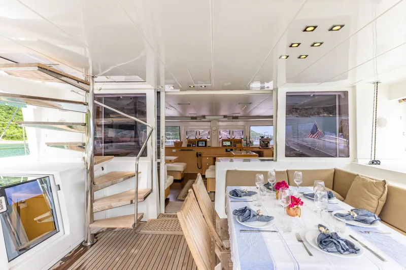 Cascadia 2 Yacht Photos Pics Luxurious interior of 2012 Lagoon 560 yacht with elegant dining area and spiral staircase.