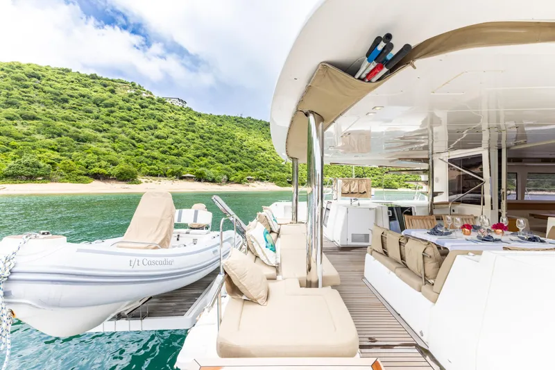 Cascadia 2 Yacht Photos Pics Luxurious 2012 Lagoon 560 yacht with spacious deck, moored near lush green island.
