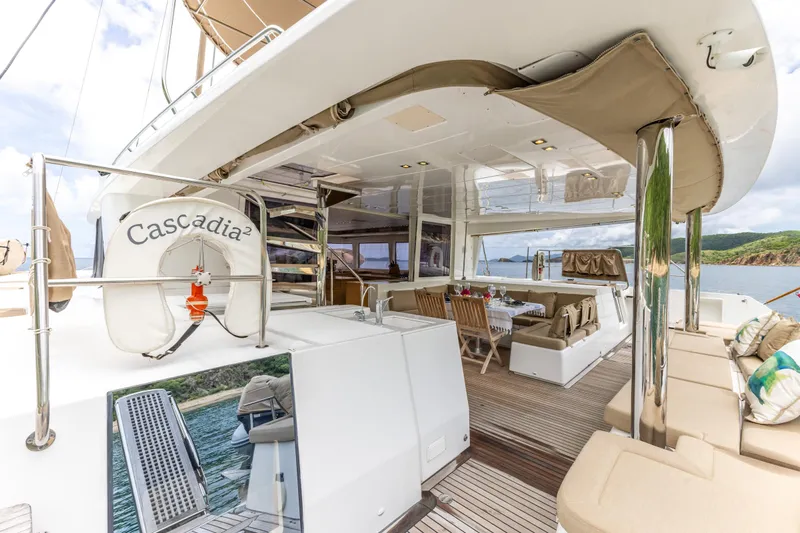 Cascadia 2 Yacht Photos Pics Luxurious 2012 Lagoon 560 yacht deck with seating, dining area, and scenic ocean view.