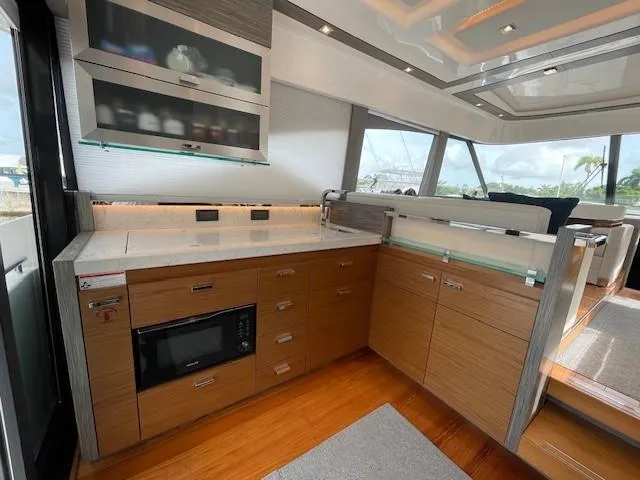 Nexlevel Yacht Photos Pics Modern kitchen area in 2019 Tiara Yachts C53 Coupe with wood cabinetry and sleek countertops.