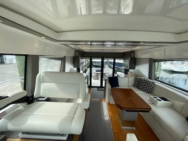 Nexlevel Yacht Photos Pics Interior of 2019 Tiara Yachts C53 Coupe with white seating and wooden table.