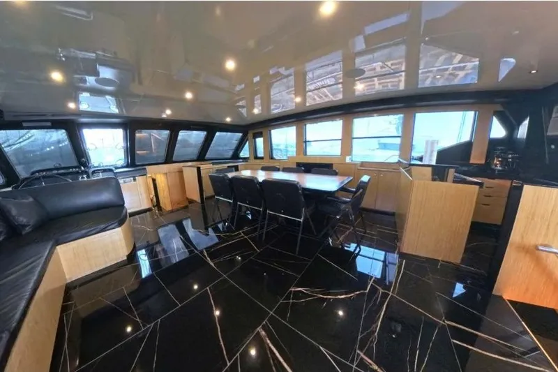 Odisea Yacht Photos Pics Luxurious interior of 2006 Custom Mahogany Expedition Gulet with sleek black flooring and modern furnishings.