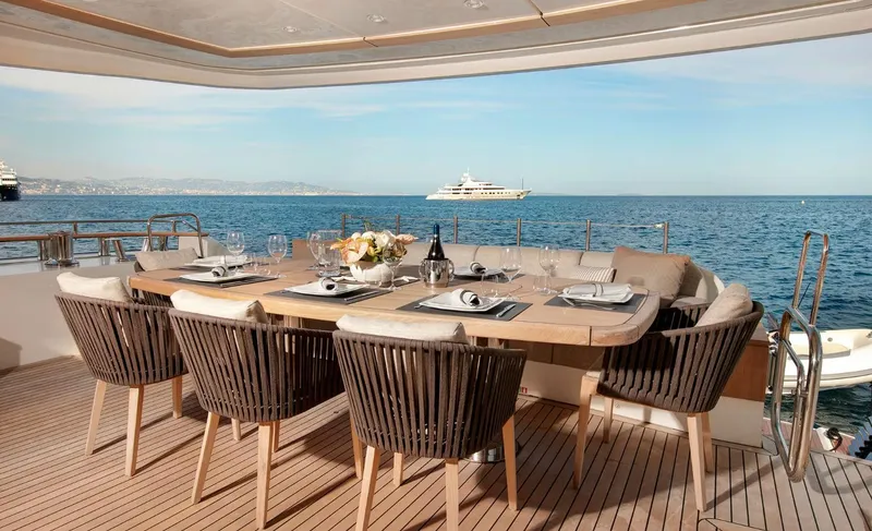 Esmeralda Of The Seas Yacht Photos Pics Luxurious dining area on 2018 Monte Carlo Yachts MCY 96, overlooking serene ocean view.