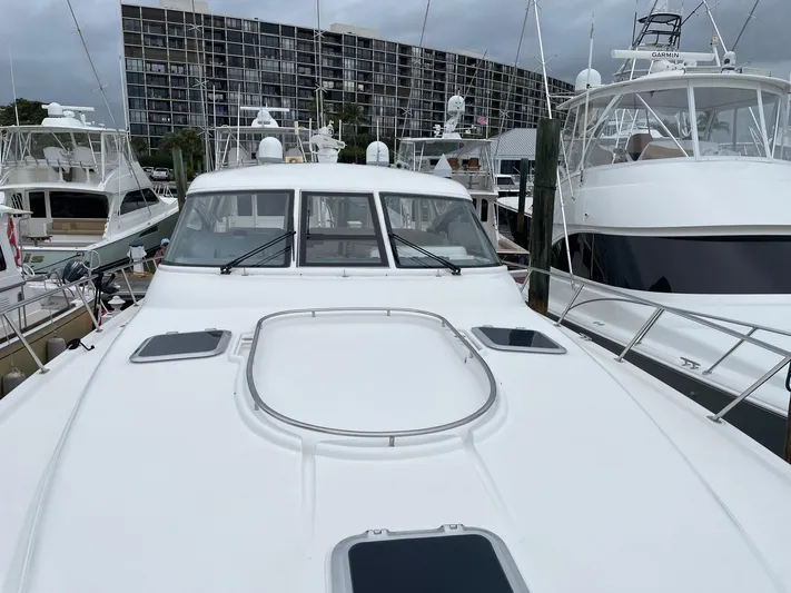 Sunshine Yacht Photos Pics 2000 Tiara Yachts 5200 Express docked among other boats in a marina.